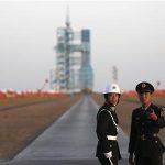 Soldiers stand in front of the Long March II-F rocket loaded with China's unmanned space module Tiangong-1 before its planned launch from the Jiuquan Satellite Launch Center, Gansu province in this September 29, 2011 file photo. REUTERS/Petar Kujundzic/Files