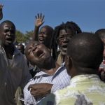Supporters of former Haitian President Jean-Bertrand Aristide react outside a courthouse in Port-au-Prince January 3, 2013. Aristide on Thursday won a delay until next week in a court hearing to address accusations he exploited former street children for political gain. REUTERS/Swoan Parker