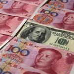 A U.S. $100 banknote is placed next to 100 yuan banknotes in this picture illustration taken in Beijing October 16, 2010. REUTERS/Petar Kujundzic
