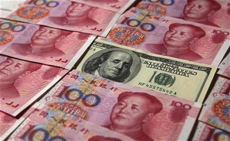 A U.S. $100 banknote is placed next to 100 yuan banknotes in this picture illustration taken in Beijing October 16, 2010. REUTERS/Petar Kujundzic