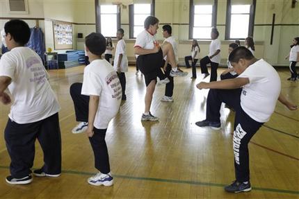 CORRECTS INFORMATION REGARDING THE STUDY'S RELEASE - FILE - In this May 26, 2009 file photo, Betty Hale, center, instructs a physical education class at Eberhart Elementary School in Chicago. Conventional wisdom says school gym classes make a big difference in kids' weight. But a report in the Thursday, Jan. 31, 2013 issue of the New England Journal of Medicine says this is one of many myths that are detracting from real solutions to the nation's weight problems. According to the report, gym classes often are not long, often or intense enough to make much difference. (AP Photo/M. Spencer Green, File)