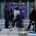 People look at a stock index board outside a brokerage in Tokyo January 30, 2013. REUTERS/Toru Hanai