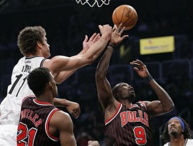 Brooklyn Nets center Brook Lopez (11) tips the ball away from Chicago Bulls forward Luol Deng (9) in the first quarter of their NBA basketball game in New York, February 1, 2013. REUTERS/Ray Stubblebine