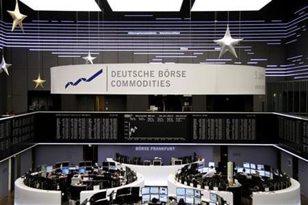 Traders are pictured at their desks in front of the DAX board at the Frankfurt stock exchange January 4, 2013. REUTERS/Remote/Joachim Herrmann