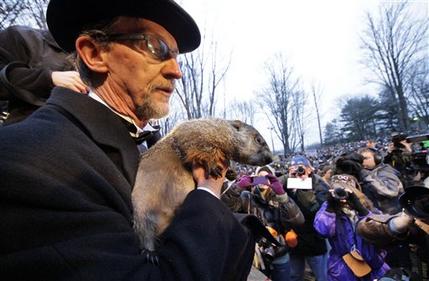 FILE - In this Feb. 2, 2012 file photo, Groundhog Club handler Ron Ploucha holds Punxsutawney Phil, the weather prognosticating groundhog, during the 126th celebration of Groundhog Day on Gobbler's Knob in Punxsutawney, Pa. Groundhog Day is Saturday, and the community is holding its welcome-back bash for the famous winter-weather prognosticator _ the so-called seer of seers and sage of sages. Legend has it that if the groundhog sees his shadow on Feb. 2, winter will last six more weeks. No shadow means an early spring. (AP Photo/Gene J. Puskar, File)