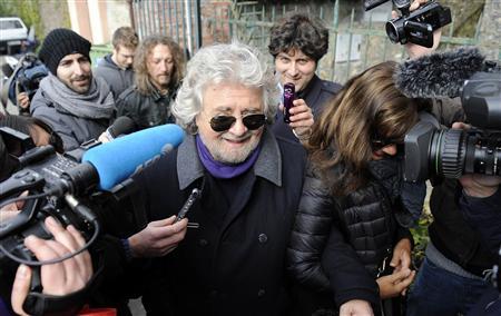 Five Star Movement leader and comedian Beppe Grillo speaks with media before casting his vote at the polling station in Genoa February 25, 2013. REUTERS/Giorgio Perottino