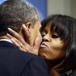 President Barack Obama kisses first lady Michelle Obama as they speak to supporters and donors at an inaugural reception for the 57th Presidential Inauguration at The National Building Museum in Washington, Sunday, Jan. 20, 2013. (AP Photo/Charles Dharapak)
