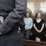 Members of the female punk band "Pussy Riot" (R-L) Nadezhda Tolokonnikova, Maria Alyokhina and Yekaterina Samutsevich sit in a glass-walled cage during a court hearing in Moscow, August 17, 2012. REUTERS/Sergei Karpukhin