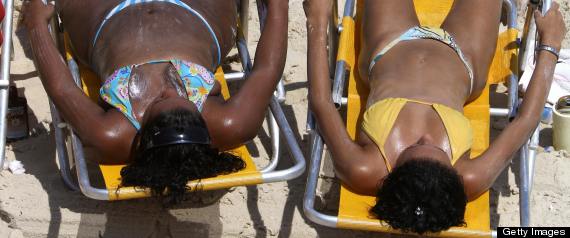 Two women sunbath at Ipanema Beach in Rio de janeiro, Brazil March 6, 2009. The level of UV radiation rose alarmingly this week in most regions in Brazil, where 13 main cities got an exposure index up to 13, of a scale from 1 to 14. The reason for the raise in the UV radiation has been ascribed to seasonal parameters, as well as to an incidental reducction of the overall cloud coverage, the Brazilian National Institite of Meterorogy sources alerted. Increased exposure to high UV levels is known to cause skin lesions and even cancer.    AFP PHOTO VANDERLEI ALMEIDA (Photo credit should read VANDERLEI ALMEIDA/AFP/Getty Images)