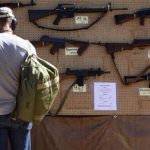 A man look at different rental guns displayed during the Big Sandy Shoot in Mohave County, Arizona March 22, 2013. REUTERS/Joshua Lott