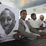 A Somali journalist holds a poster bearing the image of Abdiaziz Abdinur Ibrahim as they demand for his release in capital Mogadishu January 27, 2013. REUTERS/Feisal Omar