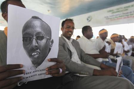 A Somali journalist holds a poster bearing the image of Abdiaziz Abdinur Ibrahim as they demand for his release in capital Mogadishu January 27, 2013. REUTERS/Feisal Omar