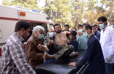 Residents and medics transport a Syrian Army soldier, wounded in what they said was a chemical weapon attack near Aleppo, to a hospital March 19, 2013. REUTERS/George Ourfalian
