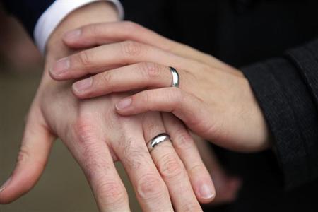 Bernie Liang (L), and Ryan Hamachek, show their rings after getting married outside Seattle City Hall in Seattle, Washington December 9, 2012. REUTERS/Cliff Despeaux