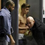 Bodyguards try to block the view of Canadian singer Justin Bieber as he goes through Wladyslaw Reymont Airport in Lodz following his concert March 25, 2013. REUTERS/Tomasz Stanczak/Agencja Gazeta
