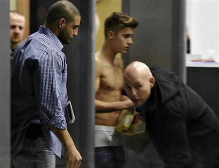 Bodyguards try to block the view of Canadian singer Justin Bieber as he goes through Wladyslaw Reymont Airport in Lodz following his concert March 25, 2013. REUTERS/Tomasz Stanczak/Agencja Gazeta