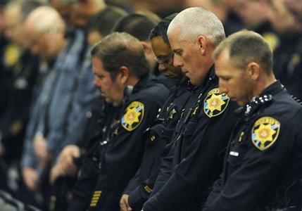 Law enforcement officers bow their head during the memorial of Tom Clements. The public memorial for the chief executive of the Department of Corrections was held at New Life Church in Colorado Springs, Colo., on Monday, March 25, 2013. Tom Clements was shot and killed on the doorstep of his home last week in Monument, Colorado  (AP Photo/The Gazette, Jerilee Bennett, Pool)