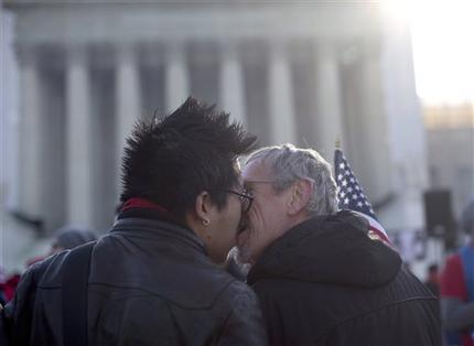 Wyatt Tan, left and Mark Nomadiou, both of New York City, kiss in front of the Supreme Court in Washington, Wednesday, March 27, 2013, prior to the start of a court hearing on the 1996 Defense of Marriage Act (DOMA). In the second of back-to-back gay marriage cases, the Supreme Court is turning to a constitutional challenge to the law that prevents legally married gay Americans from collecting federal benefits generally available to straight married couples.  (AP Photo/Carolyn Kaster)