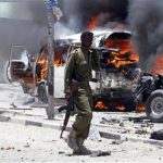 Policemen walk past the scene of an explosion near the presidential palace in Somalia's capital Mogadishu, March 18, 2013. REUTERS/Feisal Omar
