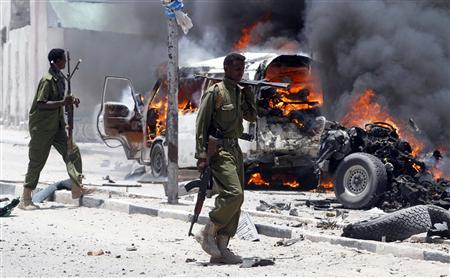 Policemen walk past the scene of an explosion near the presidential palace in Somalia's capital Mogadishu, March 18, 2013. REUTERS/Feisal Omar