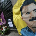 A flag with the portrait of jailed Kurdistan Workers Party (PKK) leader Abdullah Ocalan is seen in front of the entrance of the Information Centre of Kurdistan in Paris, where three Kurdish women were found shot dead, January 11, 2013. REUTERS/Christian Hartmann