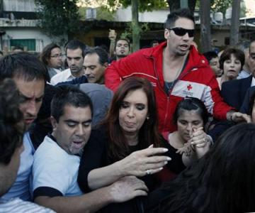 Argentina's President Cristina Fernandez de Kirchner (C) visits residents of the Villa Mitre slum affected by floods after heavy rains in Buenos Aires April 3, 2013. At least 46 people were killed in Argentina on Wednesday after a torrential downpour battered the eastern city of La Plata and forced some 2,200 people to flee their homes in search of dry ground. REUTERS/Agustin Marcarian
