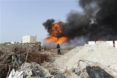 Firefighters extinguish a fire started by anti-government protesters opposing the Bahrain Formula One Grand Prix in Manama April 21, 2013. Protesters blocked several roads and police fired teargas at a school in Bahrain on Sunday, activists said, as the Gulf state staged a Formula One race promoted by the government as pure sport but seen by the opposition as a public relations stunt. REUTERS/Hamad I Mohammed