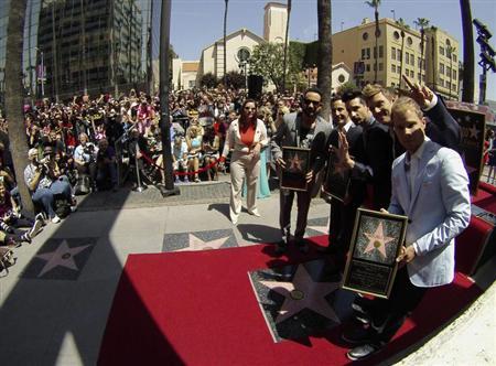 Backstreet Boys (from L-R) A. J. McLean, Howie Dorough, Kevin Richardson, Nick Carter and Brian Littrell pose by their star after it was unveiled on the Walk of Fame in Los Angeles, California April 22, 2013. REUTERS/Mario Anzuoni