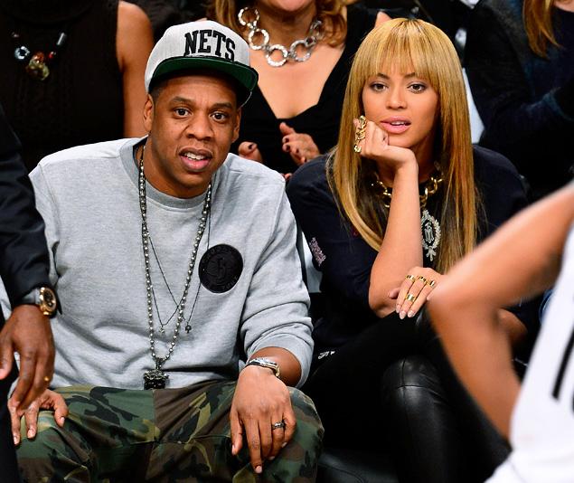 Jay-Z, here watching a game with wife Beyonce, has to relinquish his ownership in the Nets in order to become a sports agent.