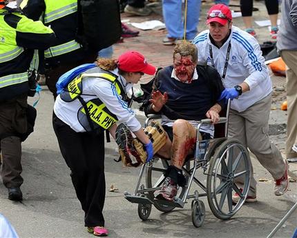 Medical workers aid an injured man at the 2013 Boston Marathon following an explosion in Boston, Monday, April 15, 2013. Two bombs exploded near the finish of the Boston Marathon on Monday, killing at least two people, injuring at least 22 others and sending authorities rushing to aid wounded spectators. (AP Photo/The Boston Globe, David L. Ryan) MANDATORY CREDIT