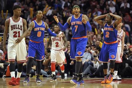New York Knicks' J.R. Smith (8), Carmelo Anthony (7) and Raymond Felton (2) react to a play late in an NBA basketball game against the Chicago Bulls, Thursday, April 11, 2013, in Chicago. Bulls' Jimmy Butler (21), Nate Robinson (2) and Kirk Hinrich walk downcourt. The Bulls won 118-111 in overtime. (AP Photo/Jim Prisching)