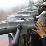 Chinese tourists look at North Korea through binoculars at an observatory just south of the demilitarized zone dividing the two Koreas, in Paju, about 55 km (34 miles) north of Seoul April 23, 2013. REUTERS/Lee Jae-Won