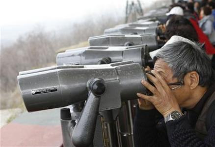 Chinese tourists look at North Korea through binoculars at an observatory just south of the demilitarized zone dividing the two Koreas, in Paju, about 55 km (34 miles) north of Seoul April 23, 2013. REUTERS/Lee Jae-Won
