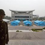 FILE - In this April 24, 2013 file photo, North Korean soldiers stand on steps overlooking the border village of Panmunjom, North Korea, which has separates the two Koreas since the Korean War. After weeks of fiery rhetoric, military posturing and threats it will strike back hard if provoked, North Korea is keeping the door open  just a crack - to the possibility of talks as U.S.-South Korea war games wind down and feelers are out in diplomatic circles that it might be best to open up some avenue for dialogue. (AP Photo/David Guttenfelder, File)