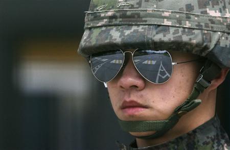 An empty road connecting the KIC (Kaesong industrial complex) with the South's CIQ (Customs, Immigration and Quarantine) is reflected in sunglasses of a South Korean soldier standing guard at the South's CIQ, just south of the demilitarised zone separating the two Koreas, in Paju, north of Seoul April 10, 2013. REUTERS/Kim Hong-Ji