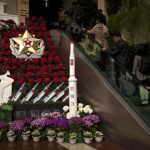 People visit a flower show featuring thousands of Kimilsungia flowers, named after the late leader Kim Il Sung, while models of a rocket and missiles are also displayed in Pyongyang, North Korea, Friday, April 12, 2013. (AP Photo/Alexander F. Yuan)