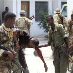 Somali soldiers help an injured civilian near the scene of a deadly blast in Mogadishu April 14, 2013. REUTERS/Feisal Omar