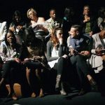 In this photograph taken Thursday April 11, 2013, South Africans wait for the start of a fashion show in Johannesburg.This month, South Africa opened a conversation _ not the first _ over the extent to which the shadow of apartheid drives today's social ills as society fights to overturn entrenched imbalances in services and opportunities. The fresh discussion began with reported comments by Trevor Manuel, national planning minister, that South African officials should assume full responsibility and resist the temptation to continually blame apartheid for missteps.(AP Photo/Jerome Delay)