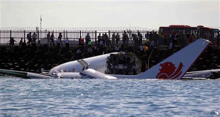 The wreckage of a Lion Air Boeing 737 -800 airplane is seen in the water near Ngurah Rai airport in Denpasar, Bali April 14, 2013. All 108 passengers and crew miraculously survived when the airplane missed the runway on the balmy Indonesian resort island of Bali on Saturday and landed in the sea. REUTERS/Stringer