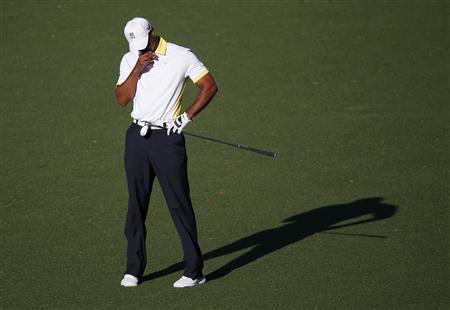 Tiger Woods reacts after a chip shot to the 15th green hit the flag pole and rolled into Rae's Creek during second round play in the 2013 Masters golf tournament at the Augusta National Golf Club in Augusta, Georgia, April 12, 2013. REUTERS/Mike Segar