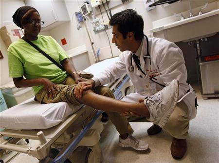 Patient Sharon Dawson Coates has her knee examined by Dr. Narang at University of Chicago Medicine Urgent Care Clinic in Chicago, June 28, 2012. REUTERS/Jim Young