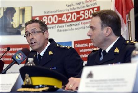 RCMP Chief Superintendent Gaeten Courchesne (L) speaks during a news conference as Assistant Commissioner James Malizia (R) looks on in Toronto, Ontario, April 22, 2013. REUTERS/Aaron Harris (CANADA - Tags: CRIME LAW TRANSPORT CIVIL UNREST)