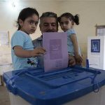 A man holds his daughters as he casts his ballot during the country's provincial elections at a polling station in Basra, 420 km (261 miles) southeast of Baghdad, April 20, 2013. REUTERS/Atef Hassan