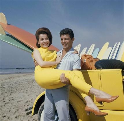 FILE - In this 1963 file photo, singer Frankie Avalon and actress Annette Funicello are seen on Malibu Beach during filming of "Beach Party," in California in 1963. Walt Disney Co. says, Monday, April 8, 2013, that former "Mouseketeer" Funicello, also known for her beach movies with Avalon, has died at age 70. (AP Photo/File)