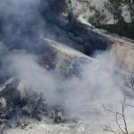 A fire burns at the site of a CSX freight train derailment, Tuesday, May 28, 2013, in Rosedale, Md., where fire officials say the train crashed into a trash truck, causing an explosion that rattled homes at least a half-mile away and collapsed nearby buildings, setting them on fire. (AP Photo/Patrick Semansky)