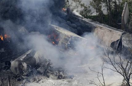 A fire burns at the site of a CSX freight train derailment, Tuesday, May 28, 2013, in Rosedale, Md., where fire officials say the train crashed into a trash truck, causing an explosion that rattled homes at least a half-mile away and collapsed nearby buildings, setting them on fire. (AP Photo/Patrick Semansky)