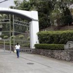 A woman walks towards the entrance to Residencial Las Terrazas in the mountains near Santa Ana, Costa Rica, Tuesday, May 28, 2013. Costa Rican police raided one of residences of Las Terrazas as well as two other homes and five businesses related to Liberty Reserve and seized papers and digital documents that will be turned over to U.S. authorities. Costa Rican police said in a statement that Liberty Reserve founder Arthur Bodovsky, who became a Costa Rica national after giving up his U.S. citizenship, was arrested in Spain last week on money laundering charges, and that several properties linked to his company had been raided. (AP Photo/Enrique Martinez)