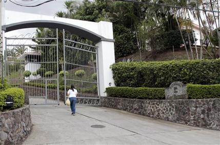 A woman walks towards the entrance to Residencial Las Terrazas in the mountains near Santa Ana, Costa Rica, Tuesday, May 28, 2013.  Costa Rican police raided one of residences of Las Terrazas as well as two other homes and five businesses related to Liberty Reserve and seized papers and digital documents that will be turned over to U.S. authorities. Costa Rican police said in a statement that Liberty Reserve founder Arthur Bodovsky, who became a Costa Rica national after giving up his U.S. citizenship, was arrested in Spain last week on money laundering charges, and that several properties linked to his company had been raided. (AP Photo/Enrique Martinez)
