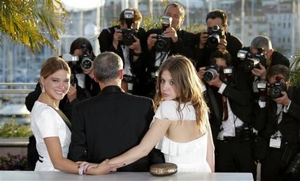 Actress Lea Seydoux, left, director Abdellatif Kechiche, centre, and Adele Exarchopoulos pose with the Palme d'Or award for the film La Vie D'Adele during a photo call after an awards ceremony at the 66th international film festival, in Cannes, southern France, Sunday, May 26, 2013.  (AP Photo/Lionel Cironneau)