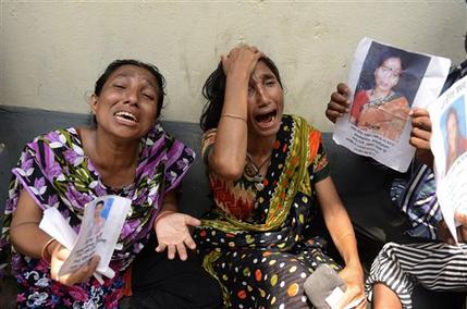 Relatives of victims from the garment factory building collapse grieve at a morgue on Wednesday May 1, 2013 in Dhaka, Bangladesh where a building housing garment factories that collapsed last week in the country's worst industrial disaster, left at least 402 people dead and injured 2,500. (AP Photo/Ismail Ferdous)